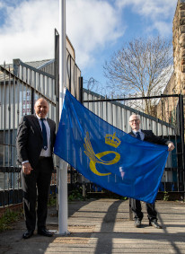 Mike Riding y Jonathan Cook de Pi levantan la bandera del Premio Queen's a la empresa
